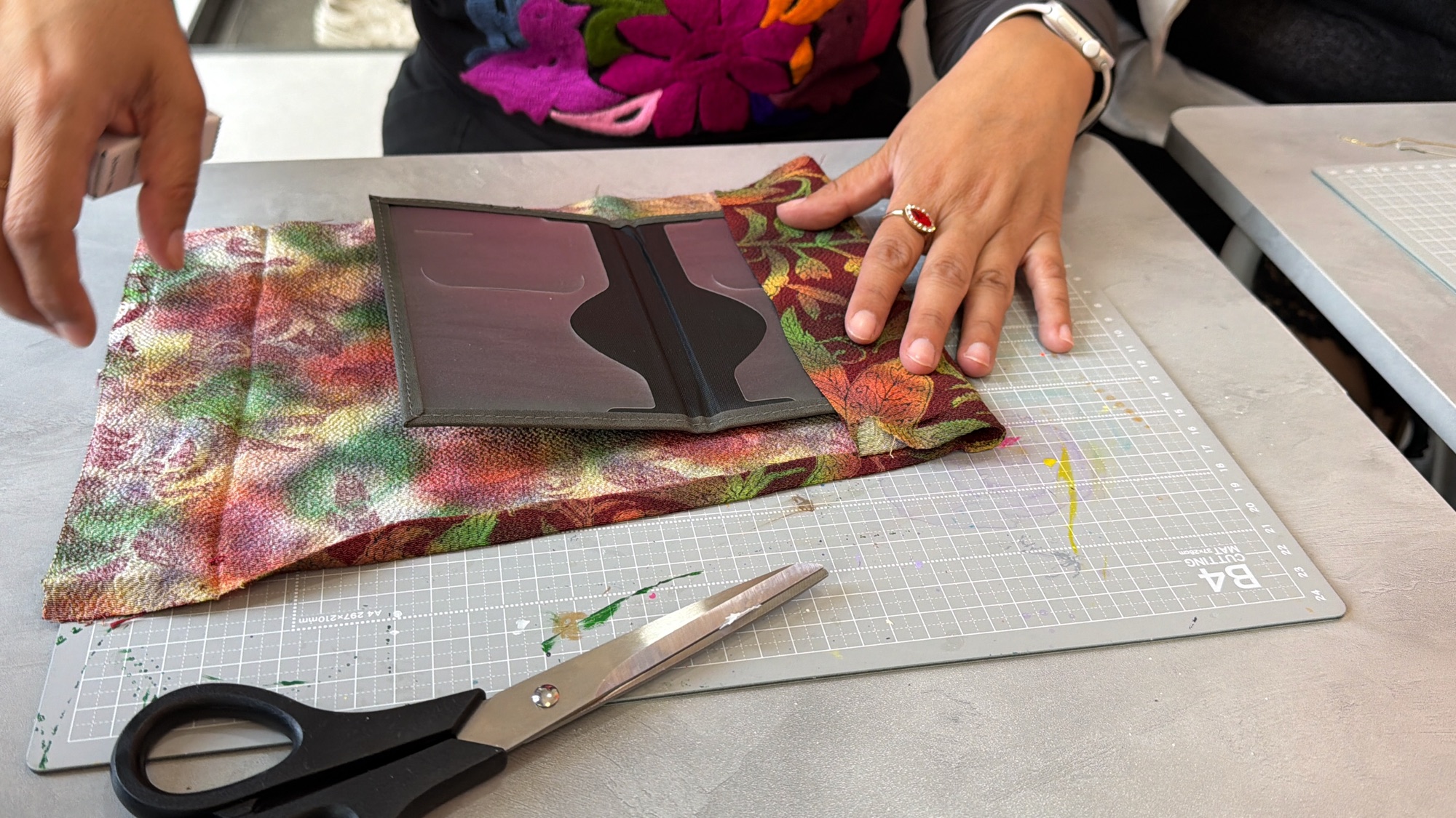 A guest assembling a richly patterned kimono project