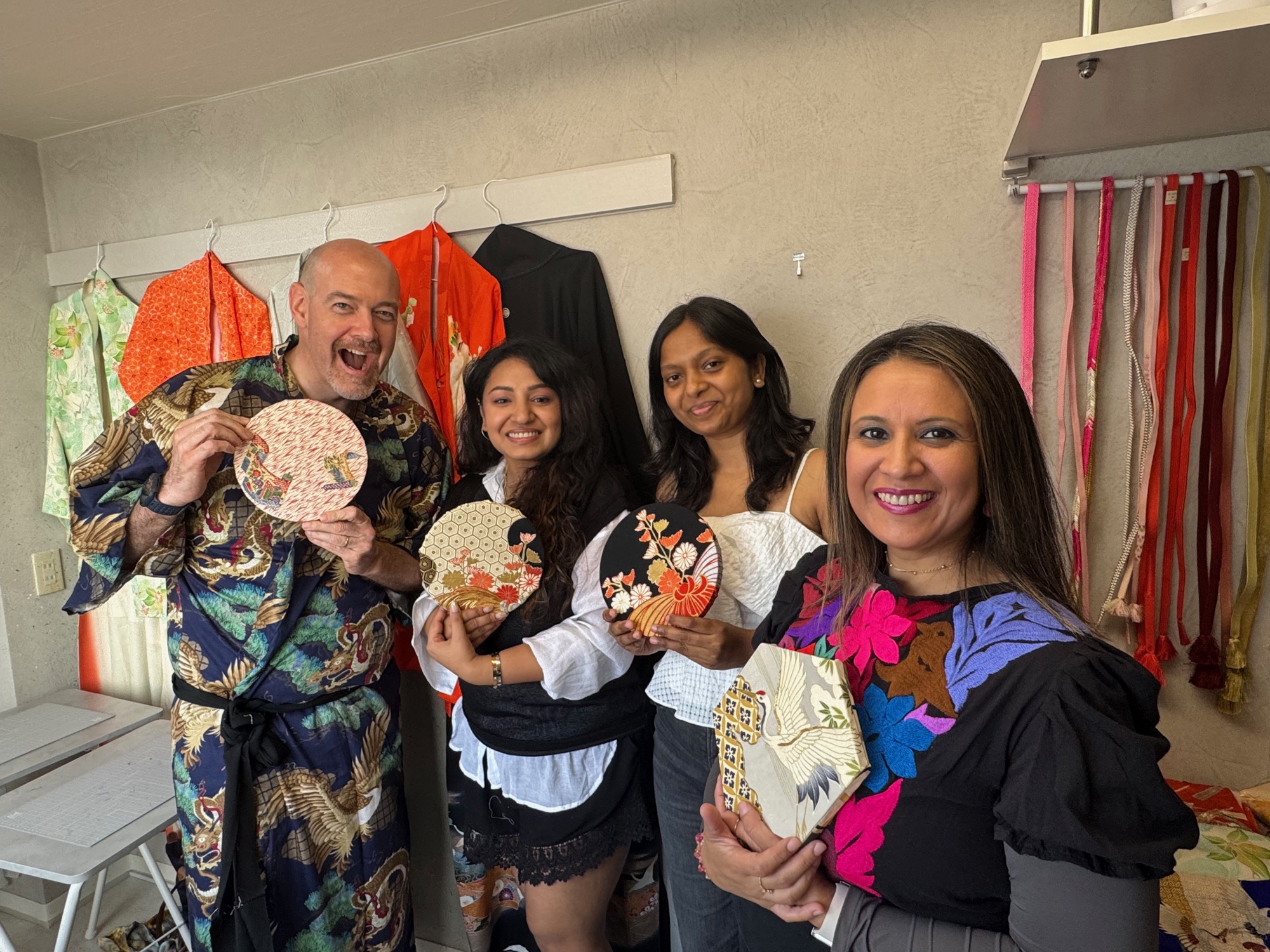 A workshop group smiling with their finished kimono pieces